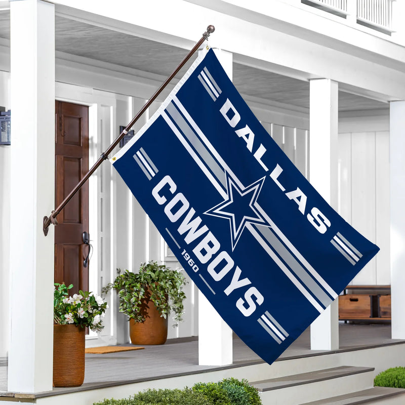 Dallas Cowboys flag on a flagpole outside a house